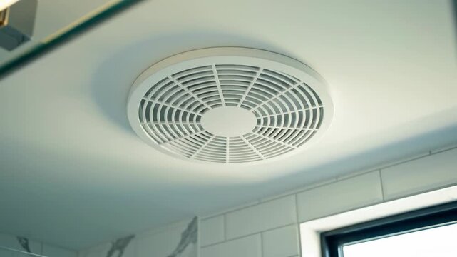 White bathroom exhaust fan installed on a ceiling.