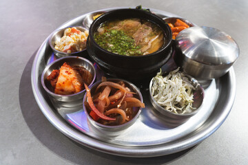 A delicious meal of Korean and hearty beef stew served hot in a bowl with rice, healthy vegetables, and tasty red tomato sauce for a nutritious lunch or dinner dish