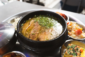 A delicious meal of Korean and hearty beef stew served hot in a bowl with rice, healthy vegetables, and tasty red tomato sauce for a nutritious lunch or dinner dish