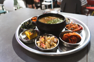 A delicious meal of Korean and hearty beef stew served hot in a bowl with rice, healthy vegetables, and tasty red tomato sauce for a nutritious lunch or dinner dish