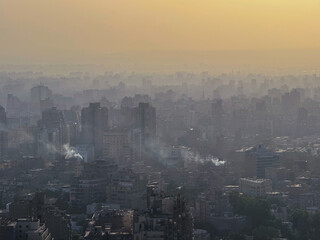 Fototapeta premium Smog and air pollution over dense urban Cairo cityscape at sunset