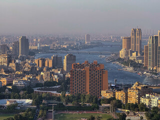 Obraz premium Cairo, Egypt - September 29, 2025: Nile River curves through modern high rise districts viewed from Cairo Tower