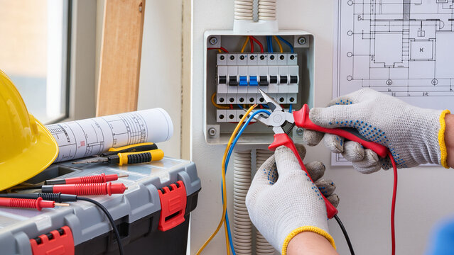 electrician repairing electrical outlet - Powered by Adobe