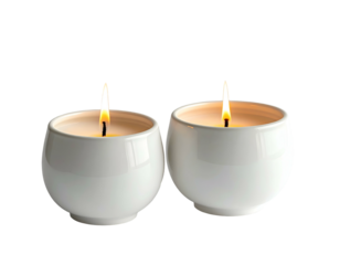 Two lit white ceramic candles in round holders