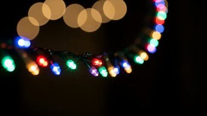 Festive string lights cast a warm glow against the dark backdrop with soft bokeh