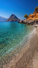 Crystal Clear Turquoise Waters Washing Up on a Pebble Beach Under Blue Sky with Distant Hills and Rocky Outcrops with Sparse Trees in Bright Sunlight