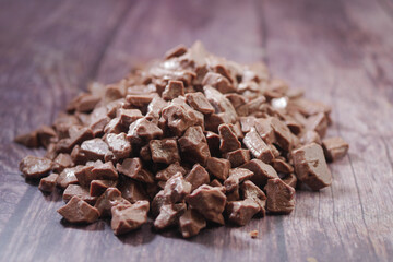 Obraz premium Chocolate pieces arranged on a wooden table surface
