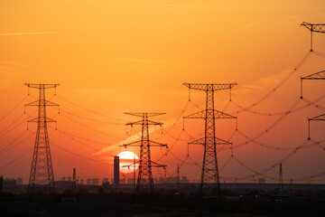High Voltage Power Lines at Sunset with City Skyline © ChuThi