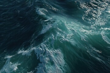 Aerial View of Dark Turquoise Ocean Waves with White Foam and Sparkling Sunlight Reflecting on Water Surface Creating Dynamic Texture and Movement