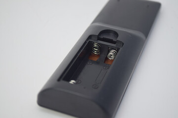 Close-up of an open battery compartment in a black plastic device showing metallic spring contacts