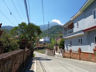 Serene mountain village street with modern homes and lush greenery