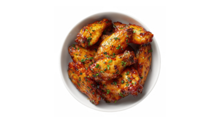 Appetizing top view of a white bowl filled with glazed chicken wings garnished with fresh herbs against a black background.
