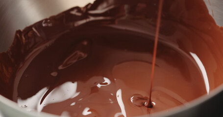 mixing dark melted chocolate with spoon closeup