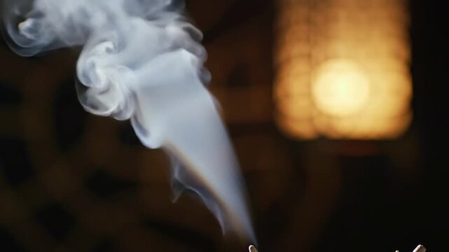 Closeup of white smoke rising from incense sticks, aromatherapy concept, wellness and spirituality.