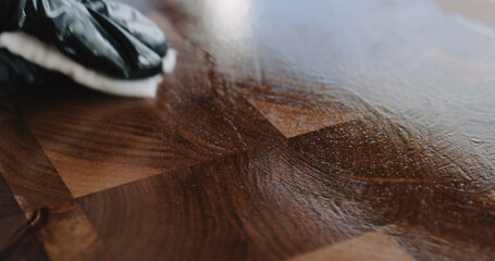 woodworker applying oil finish to walnut end grain wood board