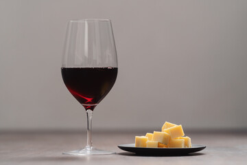 glass of red wine with vintage cheese on small plate