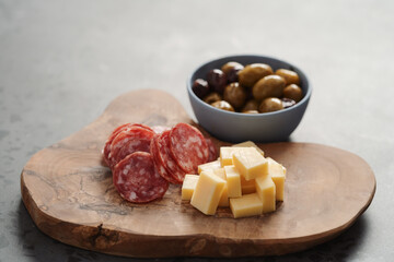 olives, salami and vintage cheese on concrete countertop