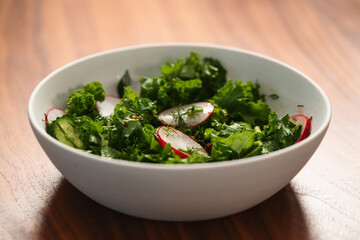 Summer fresh salad with radish, cucumber and herbs in white bowl