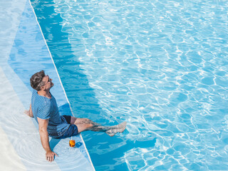 Handsome man relaxing with a drink by the cruise ship pool on a sunny, clear morning. Top view. Vacation and travel concept. Chill lifestyle, luxury travel. Perfect for holiday and travel themes © Svetlana