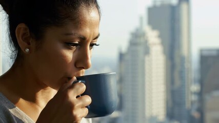 Profile of Hispanic woman in office with cityscape view, looking down, business success, focus, and determination