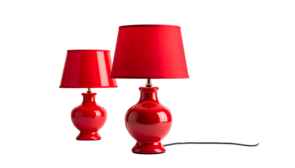 Two elegant, glossy red lamps with matching shades, against a stark black backdrop