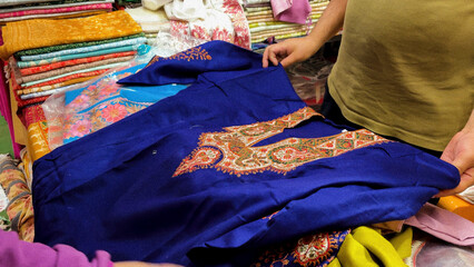 embroidered kurti textile with traditional floral patterns showing to customer