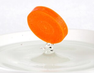 Vibrant orange slice suspended above rippling water surface