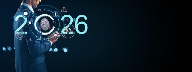 Businessman using futuristic technology interface with digital icons and glowing elements representing innovation and cybersecurity in 2026.