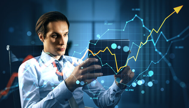Businessman analyzing rising financial market data on tablet with upward arrow and digital charts overlay in evening office background. - Powered by Adobe