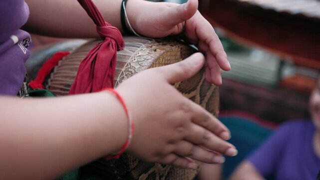 Close up of a hands playing a skor, a traditional khmer drum covered in python skin, during a cultural performance in cambodia, Siem Reap.
