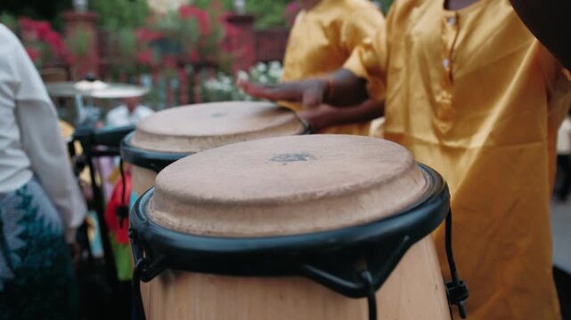Close up of a drummer hands playing traditional conga drums during an outdoor festival. The artist beats a lively rhythm on the percussion instrument in Cambodia, Siem Reap.