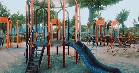 Childrens playground showcases an array of playful structures, featuring slides, climbing frames, and swings surrounded by green trees, inviting joy and laughter in sunny weather. - Powered by Adobe
