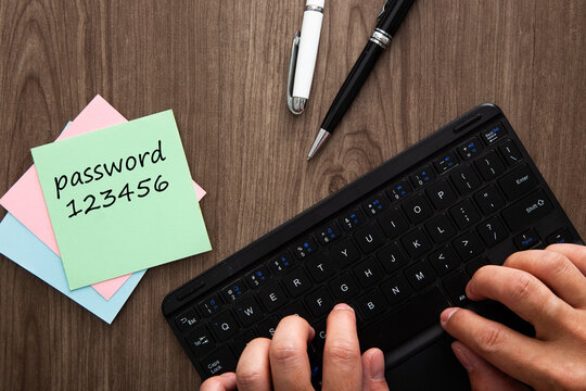 Person typing password on keyboard with weak written password