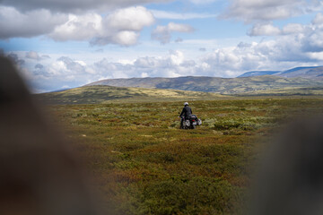 Obraz premium Lone Motorcyclist Crossing Vast Open Landscape