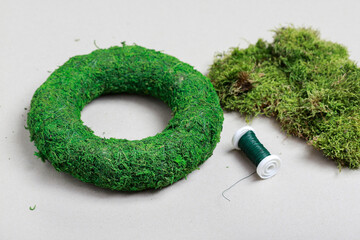 Florist at work: woman shows how to make classic moss wreath. Step by step, tutorial.