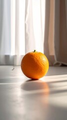 Single vibrant orange fruit resting on a light-colored floor, bathed in natural sunlight filtering through a window, creating a serene and minimalist composition.