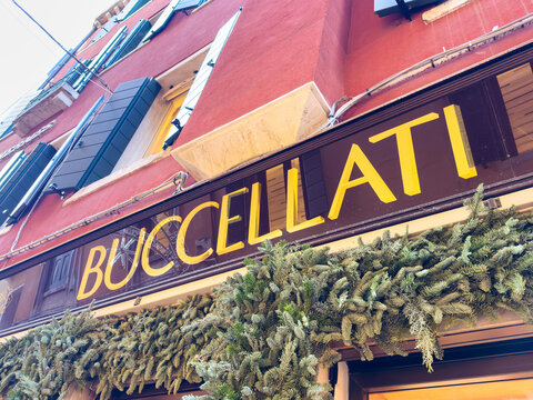 Venice, Italy - December 05, 2025: Buccellati storefront adorned with festive greenery, showcasing luxury craftsmanship in a vibrant urban setting with colorful architecture and inviting atmosphere