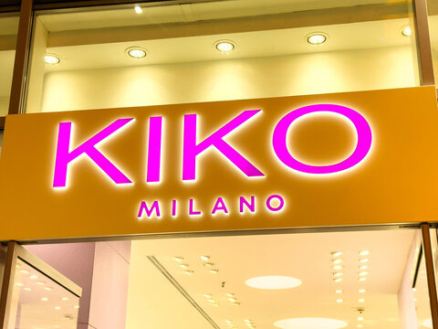Venice, Italy - December 05, 2025: KIKO Milano store sign illuminated at night, showcasing vibrant pink letters against a warm background, inviting customers to explore beauty products
