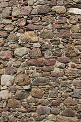 Fototapeta premium Bruchsteinmauer, rötlicher alte Mauer aus Granitsteinen