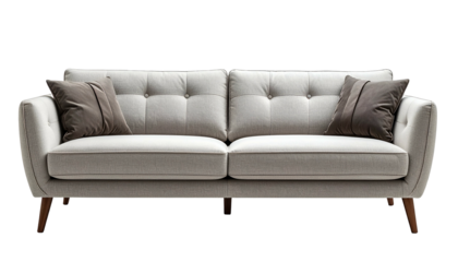 A light-colored, button-tufted sofa with two pillows, against a black background