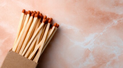 An artistic capture of a matchbox with a close-up view of wooden matches, showcasing a warm and inviting texture against a delicate marble background, highlighting simplicity.