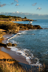 Beautiful coastal landscape, rocks, ocean, sand, and a fishing hut. Holiday background of the French coast on the Atlantic Ocean during sunset.