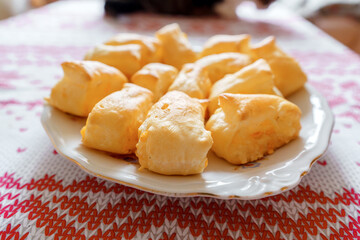 Freshly baked homemade cheese puff pastry buns on a rustic wooden board