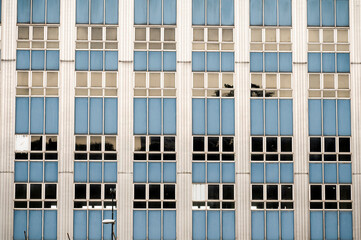 The facade of an office building from the 1990s. The texture of the building's windows.