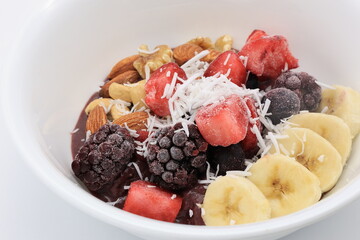 白い皿にドライフルーツやナッツが乗ったアサイーボウル