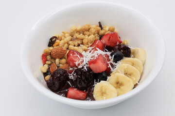 白い皿にドライフルーツやナッツが乗ったアサイーボウル