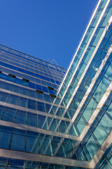 Obraz premium Abstract low-angle view of modern glass office buildings against a deep blue sky