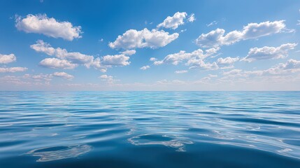 Obraz premium Open Blue Ocean Under a Partly Cloudy Sky on a Bright Sunny Day with Gentle Waves and Sparkling Sun Reflections on the Water Surface Creates Peaceful Nature Scene