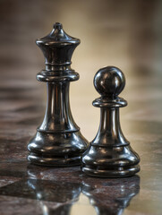 Fototapeta premium Elegant black queen and pawn chess pieces standing on a reflective checkered marble board with a blurred warm background creating a strategic atmosphere