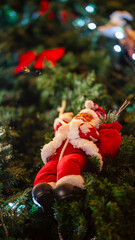 Santa Claus ornament on Christmas tree with festive lights